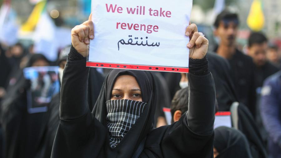 Mulher mostra cartaz que pede vingança contra o assassinato de Suleimani durante o funeral do general iraniano - AHMAD AL-RUBAYE/AFP