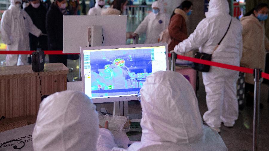 Funcionários utilizam roupas de proteção em monitoramento de temperaturas de passageiros na estação de Nanjing, na China - STRINGER