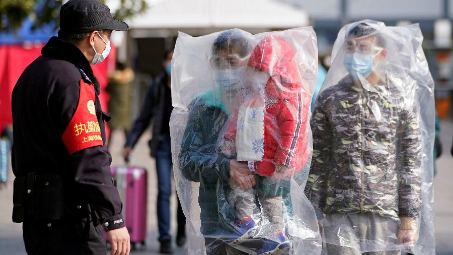 09.fev.2020 - Em Shangai, n China, família se cobre com sacolas plásticas para aumentar a proteção contra o coronavírus - ALY SONG/REUTERS