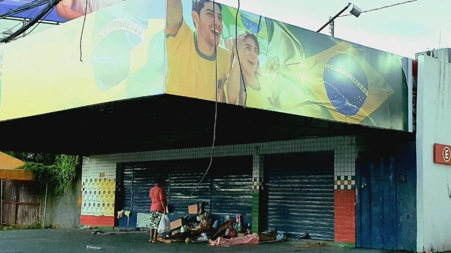 17.jul.2021 - Família se abriga embaixo de sacada de comitê de candidato em Maceió - Carlos Madeiro/UOL