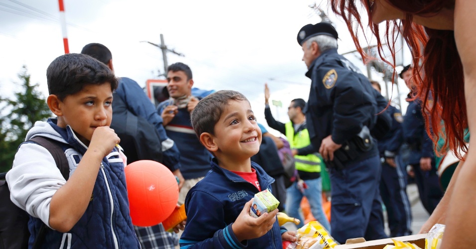 6.set.2015 - Voluntária distribui comida a migrantes em estação de trem de Nickelsdorf, na Áustria.