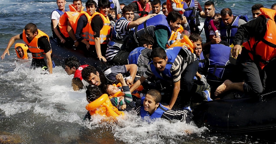 25.set.2015 - Refugiados sírios descem de bote na ilha de Lesbo, Grécia, após cruzarem o mar Egeu desde a Turquia
