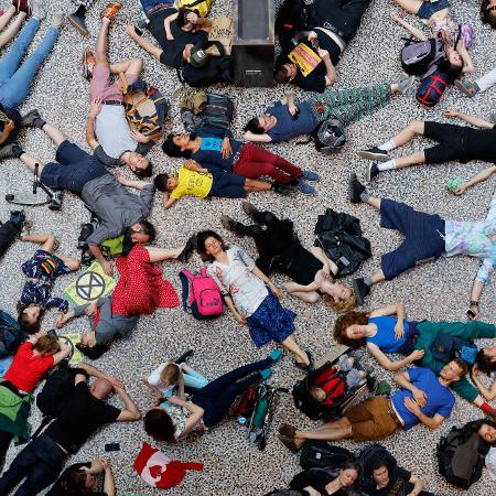 22.abr.2019 - Ativistas do grupo Extinction Rebellion deitam no chão do Museu de História Natural de Londres em um protesto de desobediência civil contra as mudanças climáticas - Tolga Akmen/AFP