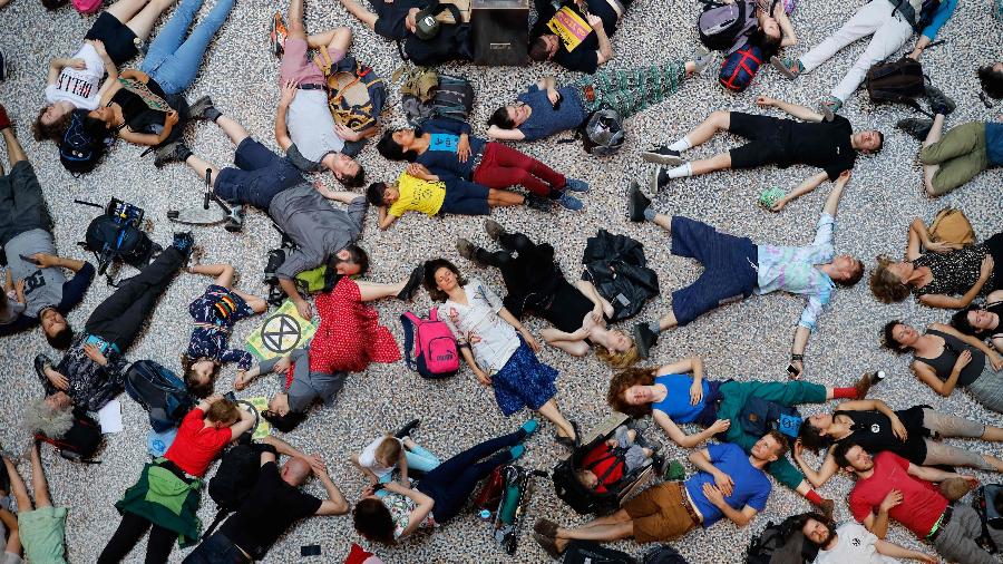 22.abr.2019 - Ativistas do grupo Extinction Rebellion deitam no chão do Museu de História Natural de Londres em um protesto de desobediência civil contra as mudanças climáticas - Tolga Akmen/AFP