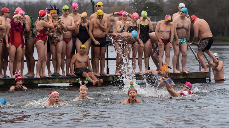 Ingleses nadam no lago gelado do Hyde Park na 161ª Corrida de Natal. 