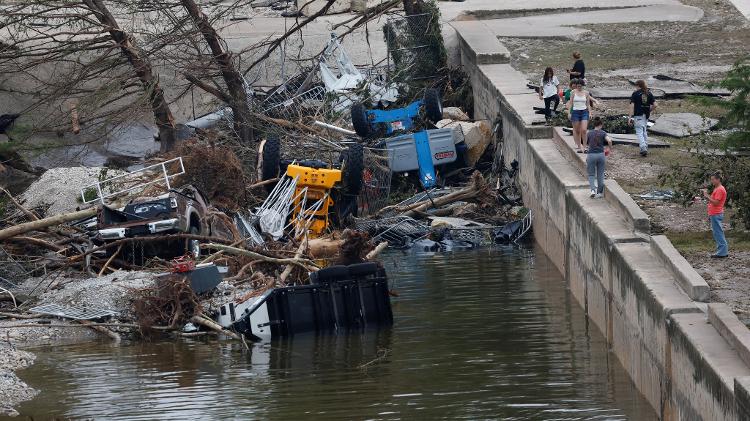Pedestres passam por destroços das chuvas que atingiram o Texas e deixaram dezenas de mortos Pedestres passam por destroços das chuvas que atingiram o Texas e deixaram dezenas de mortos