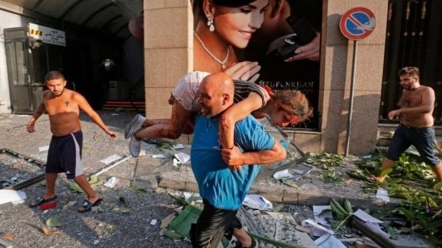 Homem retira mulher ferida de escombros em Beirute - Getty Images