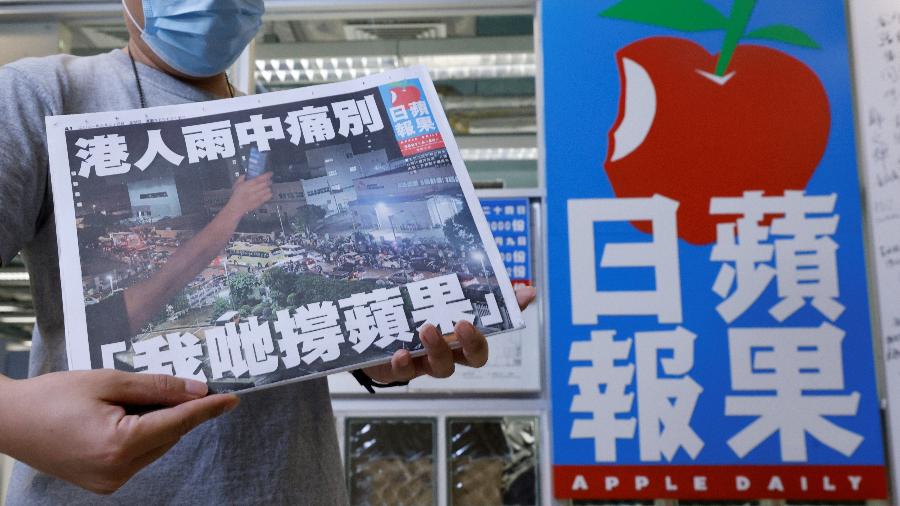 24.jun.2021 - Um membro da equipe do jornal pró-democracia Apple Daily posa com a última edição do jornal na sede da empresa em Hong Kong, China - REUTERS / Tyrone Siu