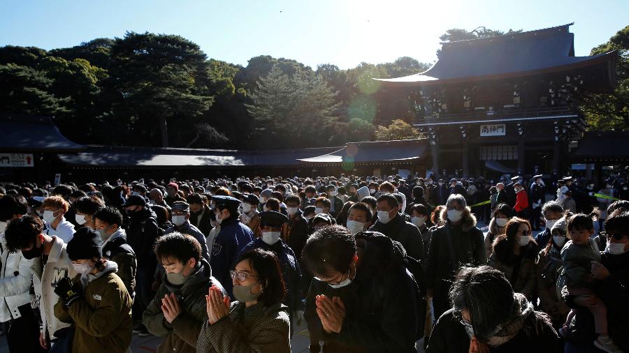 Pessoas usando máscaras de proteção rezam em praça de Tóquio no primeiro dia do ano - 1º.jan.2022 - Kim Kyung-Hoon/Reuters