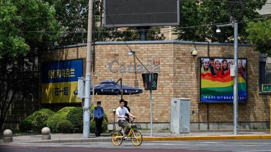 Bandeira da Ucrânia e bandeira de arco-íris com mensagem de suporte ao Dia Internacional contra a Homofobia são expostos do lado de fora da embaixada do Canadá em Pequim, na China; o governo chinês pediu que as embaixadas retirem os símbolos - HECTOR RETAMAL/AFP