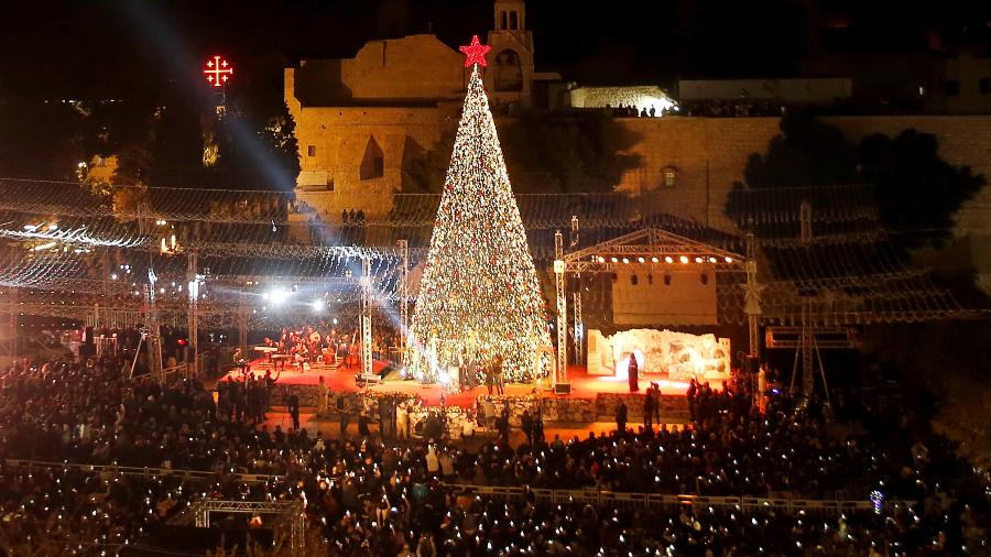 Palestinos acendem árvore de Natal na Praça da Manjedoura, em frente à Igreja da Navidade, em Belém, na Cisjordânia ocupada - 