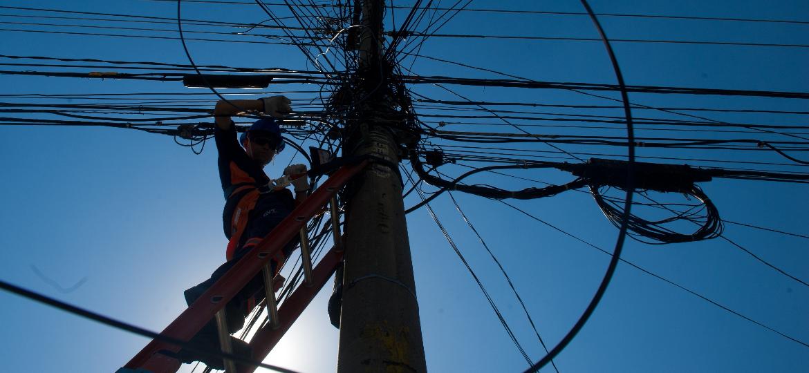 Técnico de telecomunicação instalando cabos em poste na cidade de Osasco (SP) - Luiza Sigulem/Folhapress
