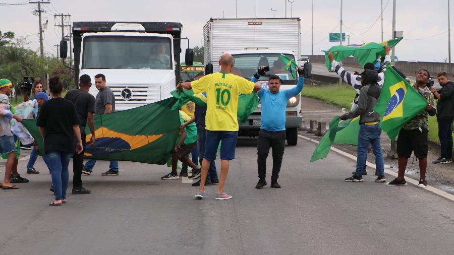 Grupo de apoiadores do presidente Bolsonaro fecha um trecho da Rodovia Washington Luiz, em frente à Refinaria Duque de Caxias, na Baixada Fluminense - José Lucena/Thenews2/Estadão Conteúdo
