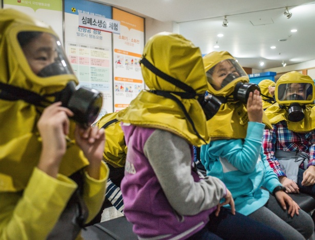 Crianças aprendem a utilizar máscara de gás em caso de ataque químico ou biológico, na Coreia do Sul - LAM YIK FEI/NYT