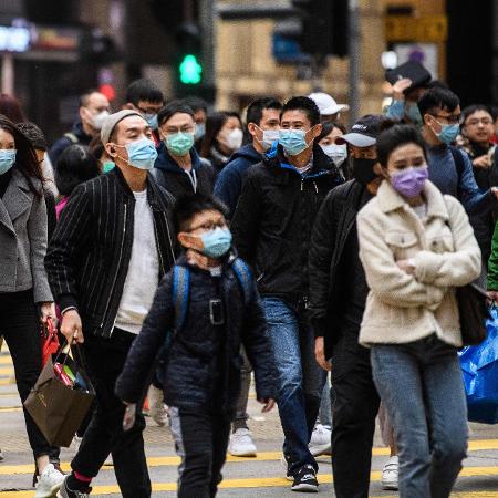 27.jan.2020 - Pedestres circulam por rua de Honk Kong de máscara - Anthony WALLACE / AFP
