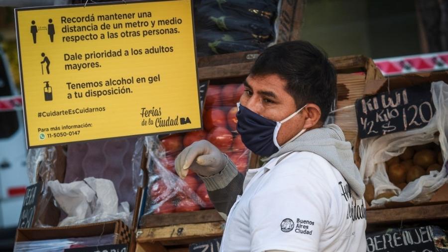 12.mai.2020 - Coronavírus: de máscara, feirante organiza sua barraca e olha o movimento em Buenos Aires, na Argentina - Marcelo Endelli/Getty Images