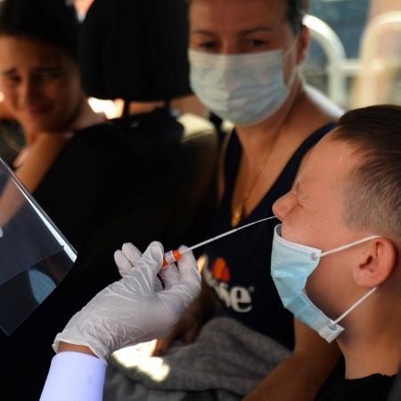 9.jul.2020 - Bióloga coleta amostra nasal de uma criança na França - Jean-François Monier/AFP