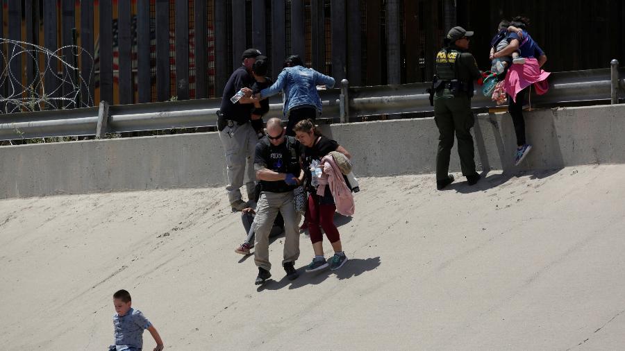 Mulheres migrantes com seus filhos são detidas pelos funcionários de alfândega e proteção de fronteiras dos EUA depois de atravessar ilegalmente para El Paso, Texas - DANIEL BECERRIL/REUTERS