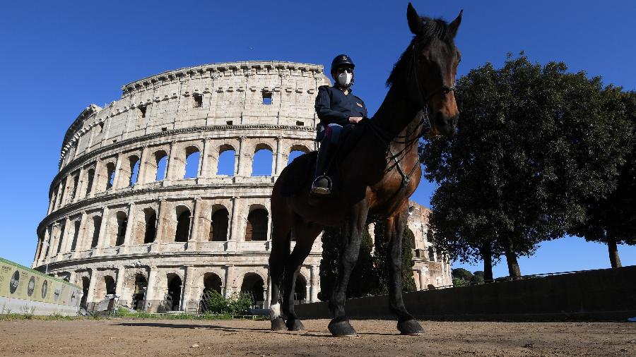 26.abr.2020 - Policial usa máscara em frente ao Coliseu, em Roma, Itália - Alberto Lingria/Reuters