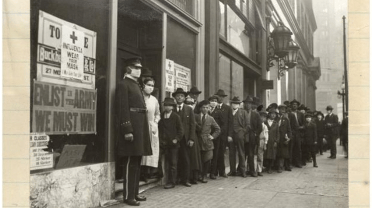Fila para distribuição de máscaras em São Francisco. Em outubro de 1918, com o avanço da pandemia de gripe, as autoridades municipais decretaram a obrigatoriedade de usar máscaras em público - California History Room, California State Library