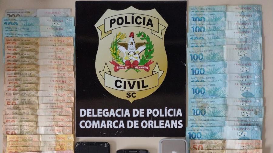 Dinheiro e um simulacro de arma foram encontrados na casa do rapaz - Divulgação/ Polícia Civil
