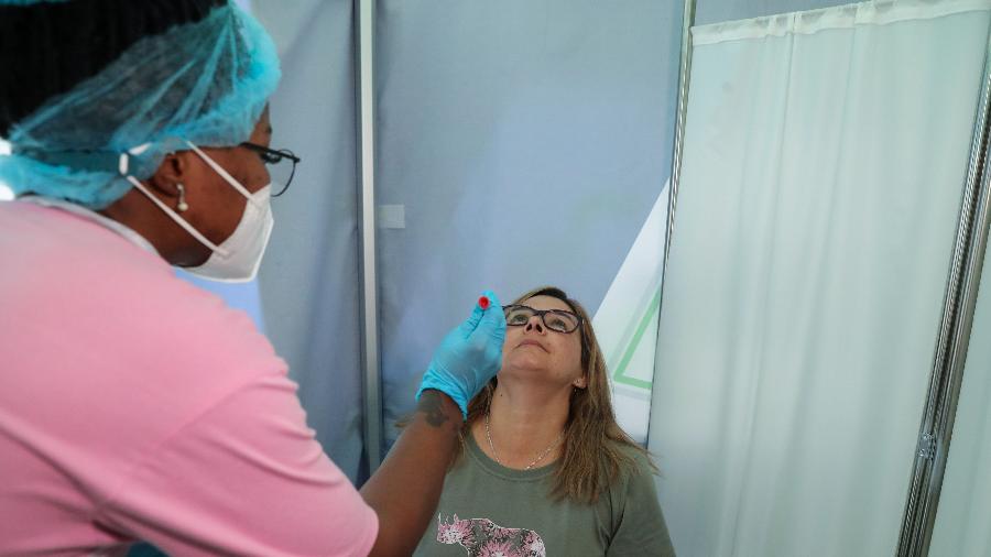 26.nov.2021 - Profissional de saúde coleta PCR de covid de uma mulher no aeroporto de Joanesburgo, na África do Sul - Sumaya Hisham/Reuters