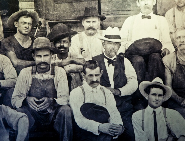 Jack Daniel (no centro, de chapéu branco) e um negro não identificado, possivelmente o escravo Nearest Green ou um de seus filhos - The New York Times