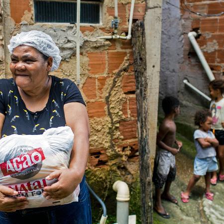 Rita Maria Vitor de Souza, 59, recebe a doação de alimentos do projeto Ação da Cidadania durante o Natal Sem Fome, no Rio de Janeiro - DANIEL RAMALHO/AFP