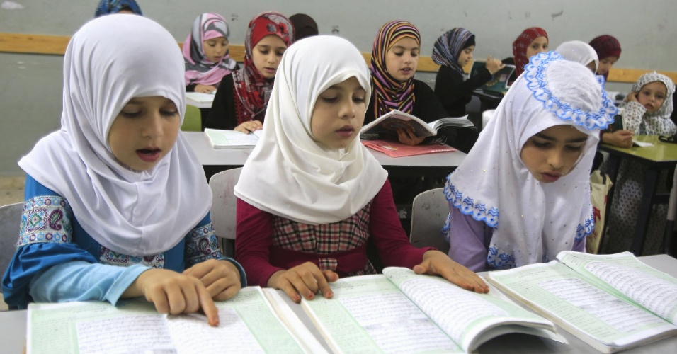 30.jun.2015 - Garotas palestinas leem o Alcorão em mesquita, durante a celebração do Ramadã, mês sagrado para os muçulmanos, na vila Aseera, na Palestina