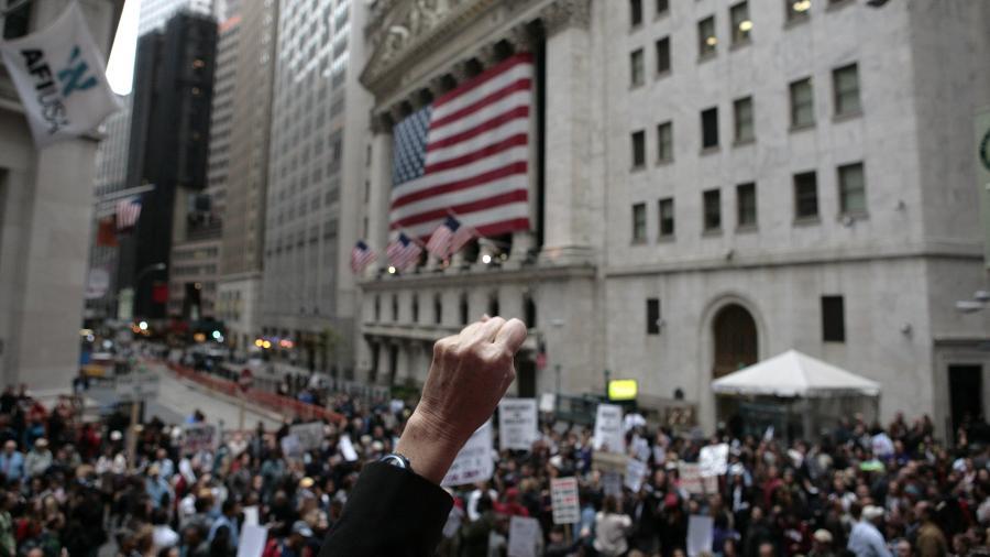 25.9.2008 - Manifestantes protestam contra o pacote de ajuda de 700 bilhões do governo norte-americano ao sistema financeiro, diante da Bolsa de Valores de Nova York - AFP