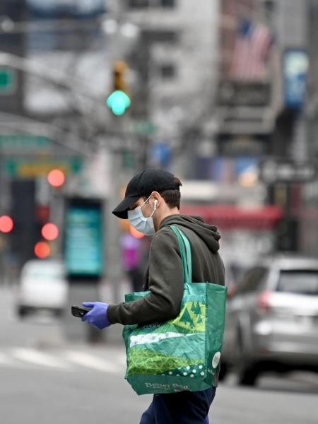 Homem usa luvas e máscara de proteção contra o novo coronavírus em Nova York  - Alexi Rosenfeld/Getty Images