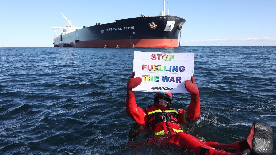 31.mar.22 - Ativista do Greenpeace segura um cartaz contra a guerra na Ucrânia em frente ao superpetroleiro Pertamina Prime, na costa da Dinamarca - KRISTIAN BUUS/AFP