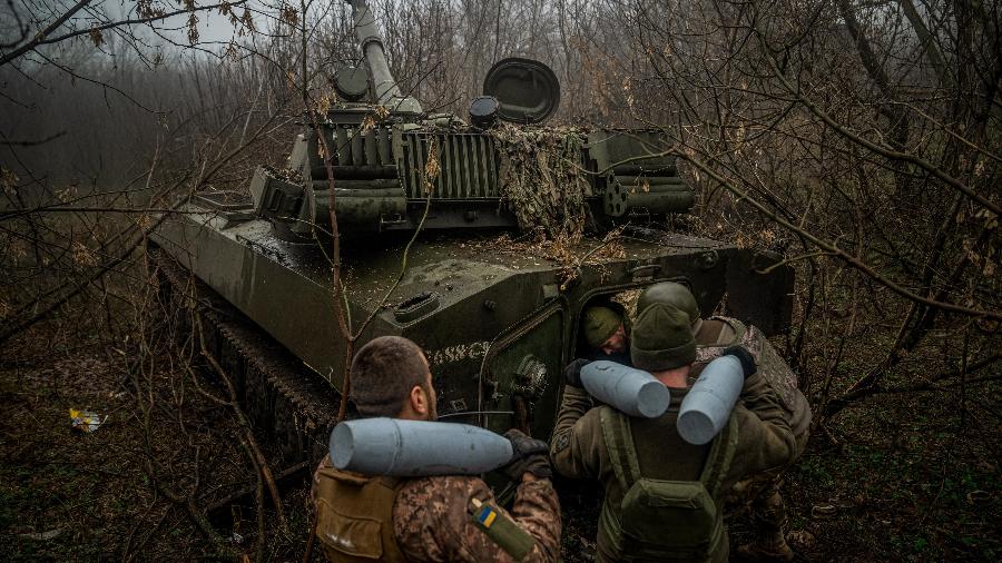 Artilheiros ucranianos da 24ª brigada carregam uma munição em uma posição ao longo da linha de frente nas proximidades de Bakhmut, região de Donetsk, em 10 de dezembro de 2022 - IHOR TKACHOV/AFP