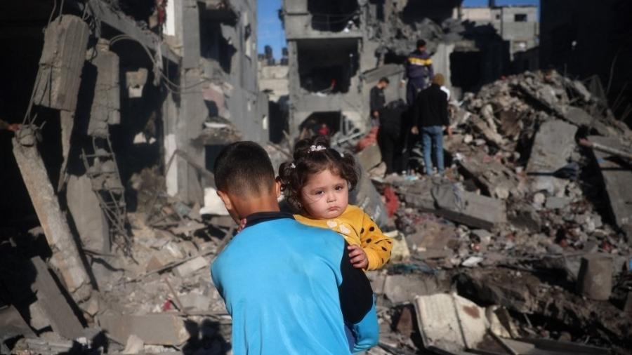 Crianças palestinas inspecionam escombros após ataques israelenses em Nuseirat Crianças palestinas inspecionam escombros após ataques israelenses em Nuseirat