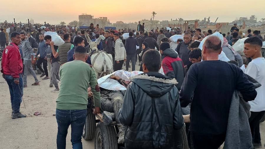 Palestinos deslocados empurram carroça com corpos após ataque perto de um centro de distribuição de alimentos em Rafah, no sul da Faixa de Gaza Palestinos deslocados empurram carroça com corpos após ataque perto de um centro de distribuição de alimentos em Rafah, no sul da Faixa de Gaza
