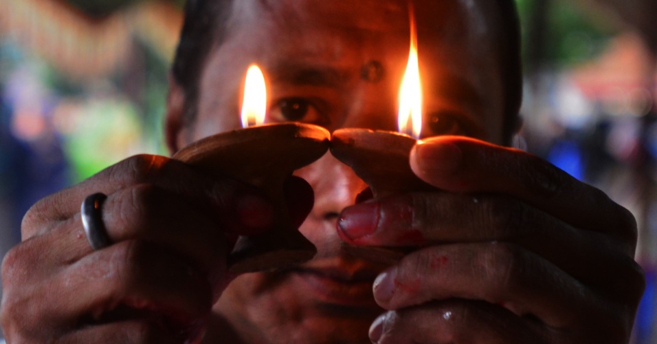 19.ago.2015 - Um devoto Hindu Nepalês com lamparinas usadas para fazer oferendas ao deus serpente conhecido como "Nag" no Nagpokhari em Katmandu, no Nepal