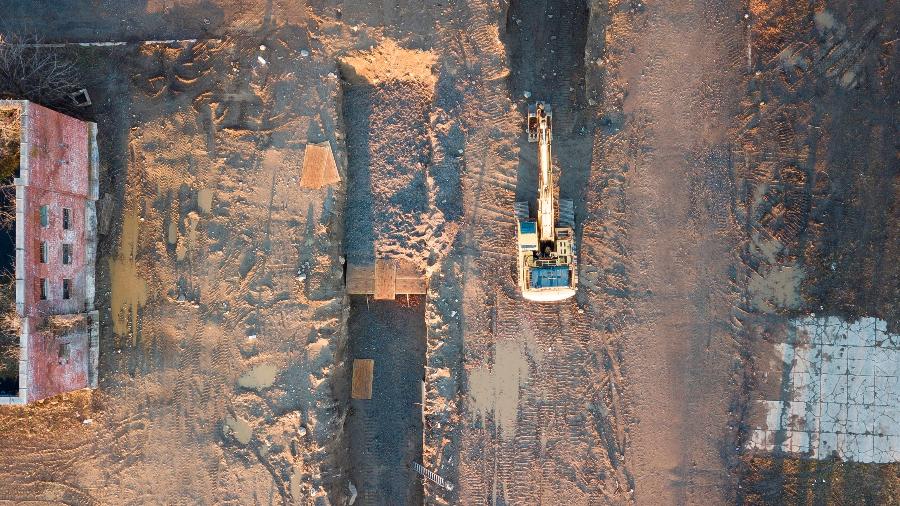 10.abr.2020 - Imagem aérea mostra uma escavadeira abrindo uma cova coletiva em Hart Island, no distrito do Bronx (Nova York), para enterrar vítimas do coronavírus - EFE/EPA/JUSTIN LANE