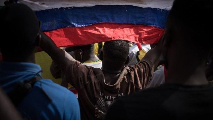 A protester holding a Russian flag during a demonstration celebrating France's announcement of its withdrawal from Mali - GETTY IMAGES - GETTY IMAGES