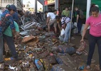 Moradores retiram alimentos da lama após destruição de supermercado no RS - Reprodução/TV Globo