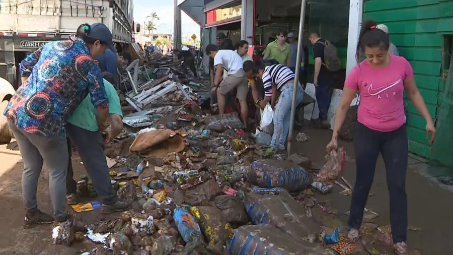 Alagamentos não pouparam o supermercado da cidade e os moradores tiveram que recolher os alimentos da lama