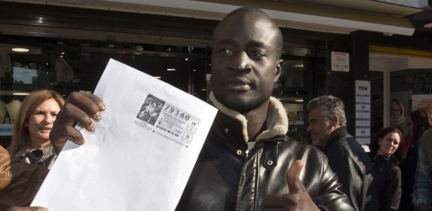 O senegalês Ngmae mostra cópia de seu bilhete premiado, em Roquetas de Mar, na Espanha - AFP
