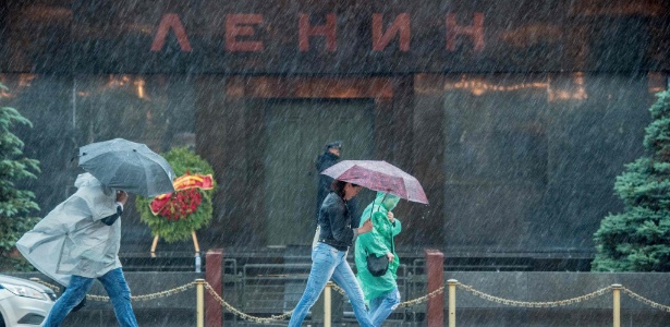 Pedestres protegem-se da chuva em Moscou: temporal deixou mortos e feridos na capital russa - Dmitry Serebryakov/AFP Photo