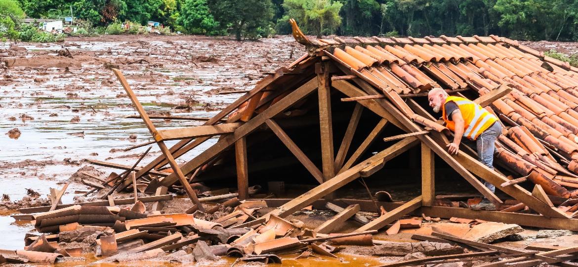 26.jan.2019 - Homem se equilibra em uma casa que foi engolida pela lama da barragem 1 da Mina do Feijão, em Brumadinho - CADU ROLIM/FOTOARENA/ESTADÃO CONTEÚDO
