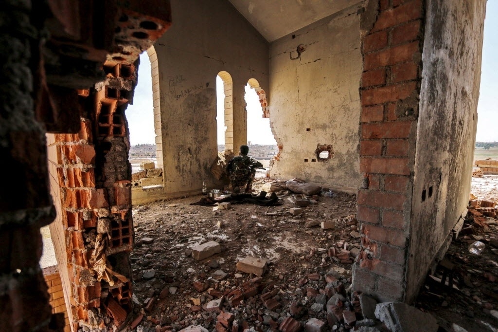 23.jul.2015 - Combatentes da Unidade de Proteção do Povo Curdo (YPG) observam a movimentação do Estado Islâmico em uma construção danificada na cidade de Hasaka, na Síria. A YPG declarou que está próxima de obter o controle do nordeste da cidade, o que seria a maior vitória para região autônoma curda que luta em parceria com os Estados Unidos - Rodi Said/Reuters