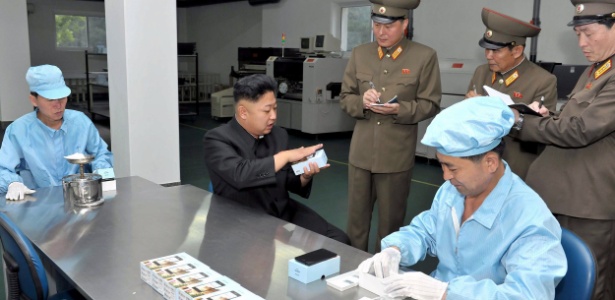 Kim Jong-un visita uma fábrica de smartphones, na Coreia do Norte - KCNA via AFP