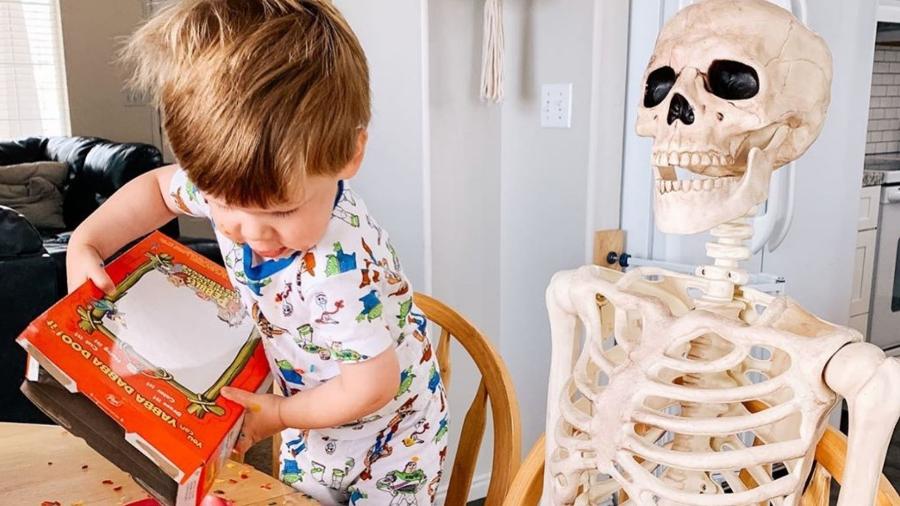 Theo, de 2 anos, ao lado de seu "amigo" esqueleto - Reprodução/@abigailkbrady/Instagram