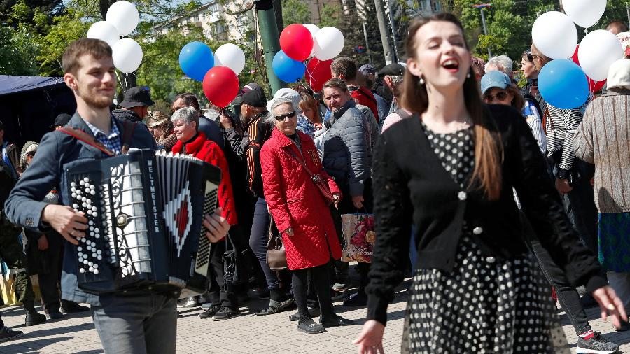 09.mai.22 - Pessoas participam de uma cerimônia que marca o 77º aniversário da vitória sobre a Alemanha nazista na Segunda Guerra Mundial, durante o conflito Ucrânia-Rússia na cidade portuária de Mariupol, no sul da Ucrânia - ALEXANDER ERMOCHENKO/REUTERS
