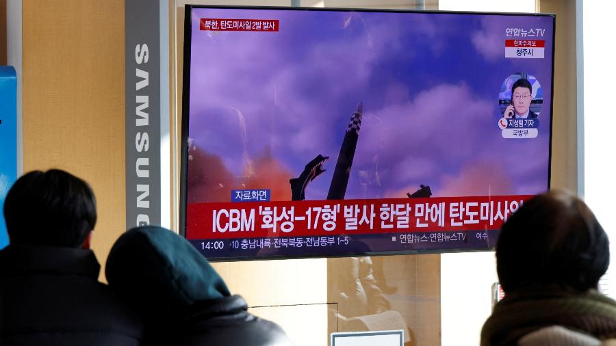 18.dez.2022 - Pessoas assistem transmissão na TV sobre a Coreia do Norte disparando mísseis - REUTERS/ Heo Ran