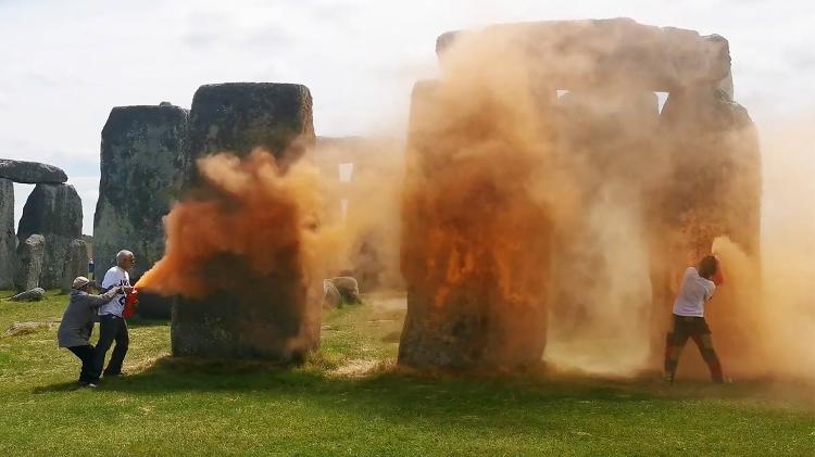 19.jun.2024 - Uma captura de imagem de um vídeo divulgado pelo grupo de campanha climática Just Stop Oil mostra ativistas pulverizando uma substância laranja em Stonehenge, em Wiltshire, sudoeste da Inglaterra 19.jun.2024 - Uma captura de imagem de um vídeo divulgado pelo grupo de campanha climática Just Stop Oil mostra ativistas pulverizando uma substância laranja em Stonehenge, em Wiltshire, sudoeste da Inglaterra