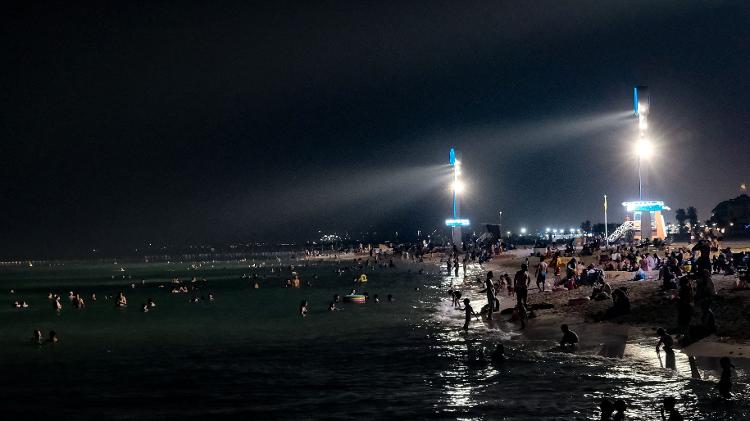 Pessoas se refrescam na praia de Umm Suqeim, em Dubai, nos Emirados Árabes Unidos, no dia de maior calor já registrado para o mês de maio no país --51,6 ºC Pessoas se refrescam na praia de Umm Suqeim, em Dubai, nos Emirados Árabes Unidos, no dia de maior calor já registrado para o mês de maio no país --51,6 ºC